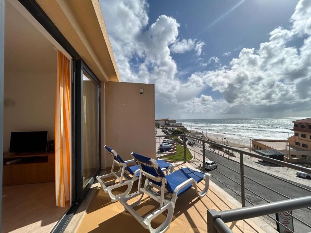 two chairs on a balcony with a view of the beach at Apartment with Breathtaking view in Praia da Areia Branca
