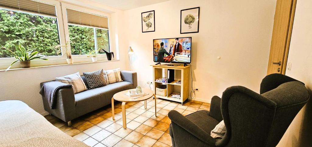 a living room with two couches and a tv at Ferienwohnung Seevetal in Glüsingen