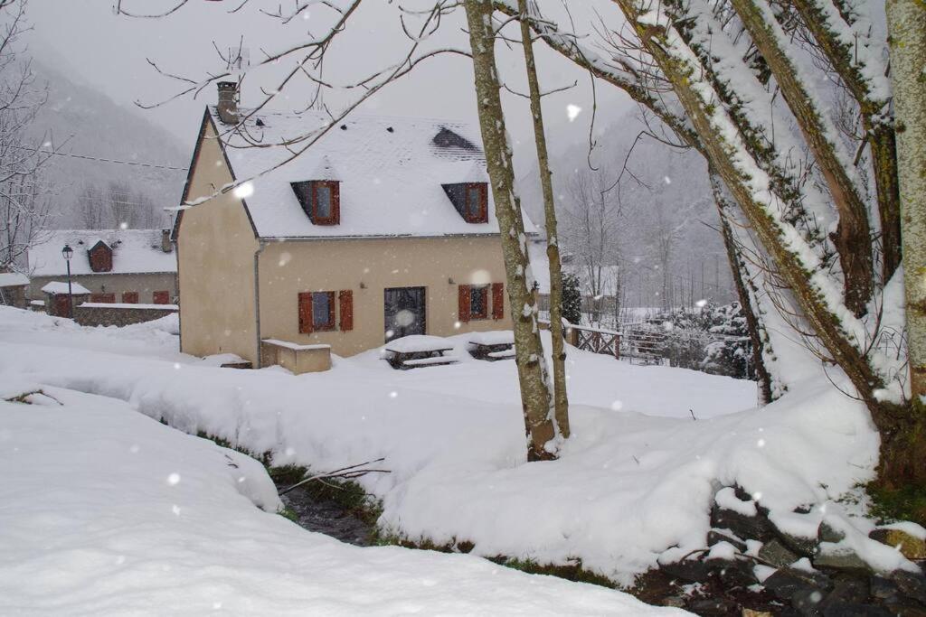 une maison recouverte de neige dans une cour dans l'établissement Maison de village à 5 minutes de St Lary Soulan, à Saint-Lary-Soulan