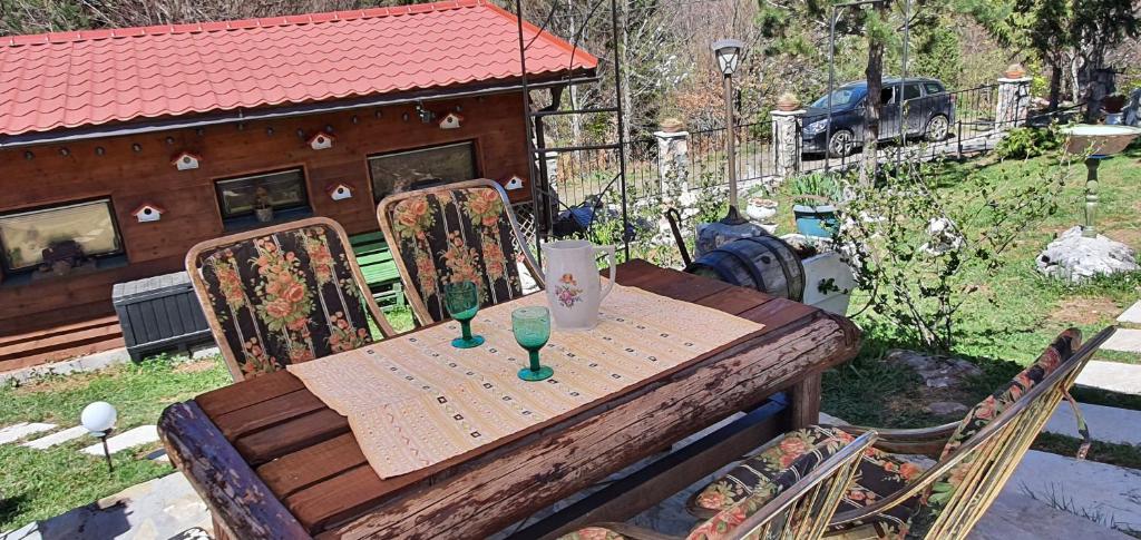 una mesa de madera con dos vasos en el patio trasero en Mountain House Reba en Zlatibor