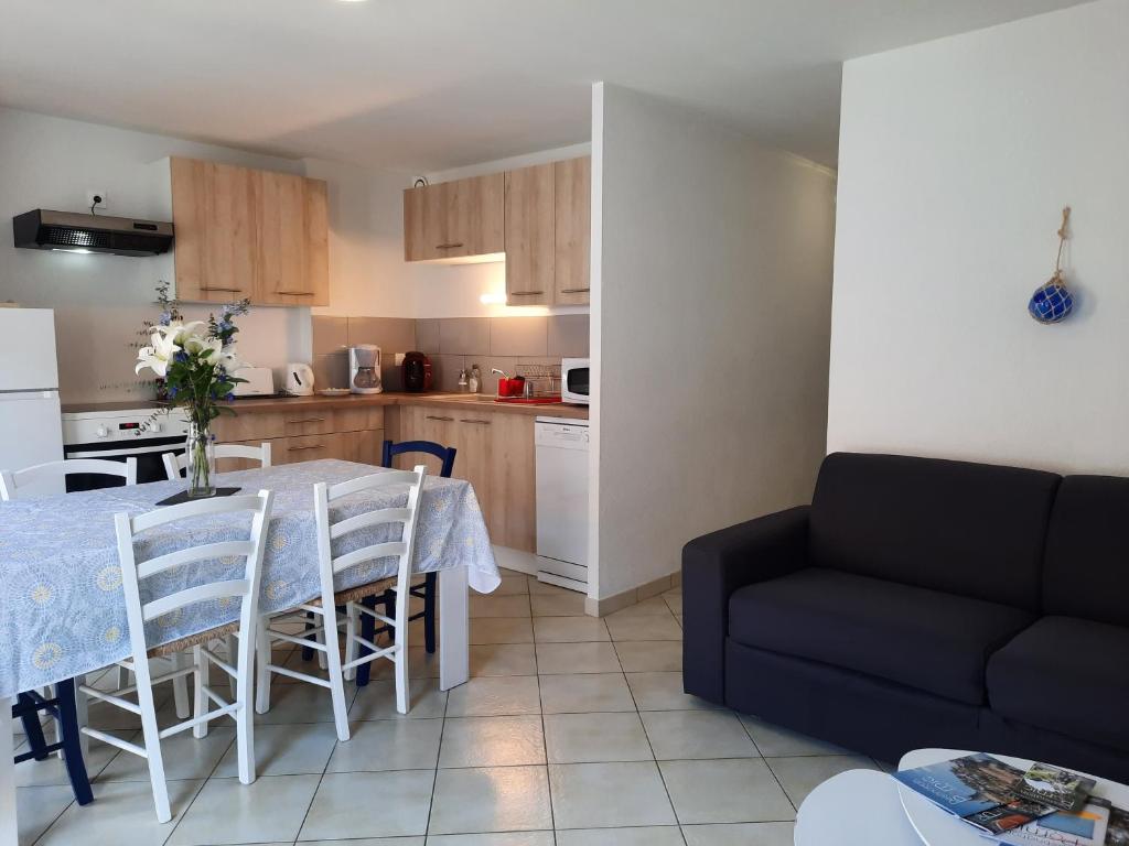 a kitchen and dining room with a table and a couch at Le créateur - Au coeur de la Ville Haute in Pornic