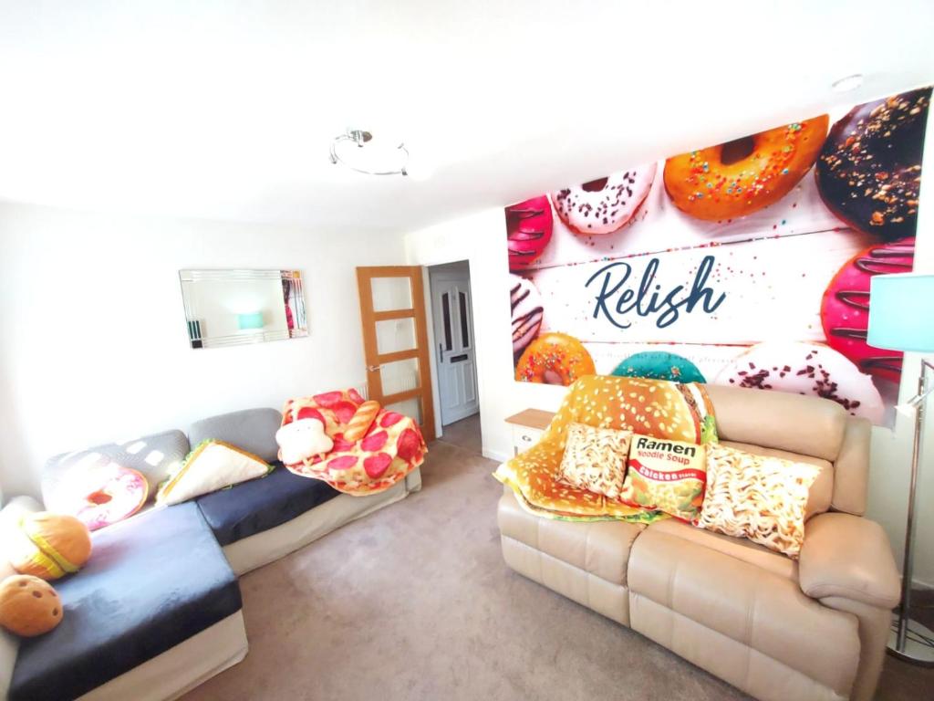 a living room with two couches and a wall with donuts at The Relish - ground floor flat in Largs in Largs