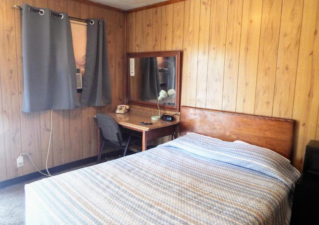 - une chambre avec un lit, un bureau et une table dans l'établissement Davis Motel, à North Lima