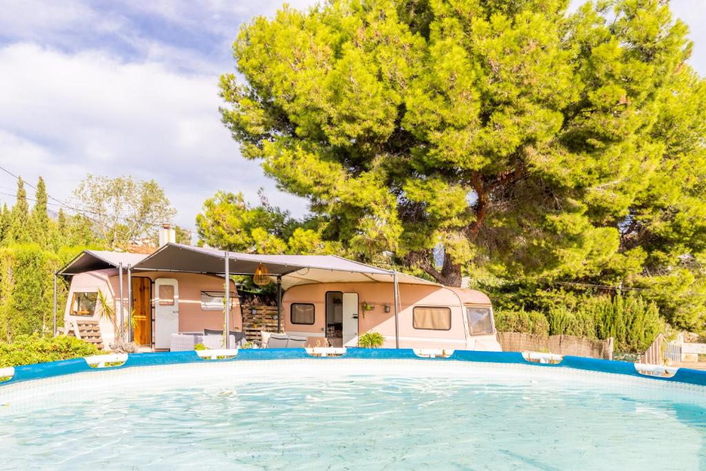 a house with a large swimming pool in front of a house at Caravana-glamping Casa Tortuga in La Nucía