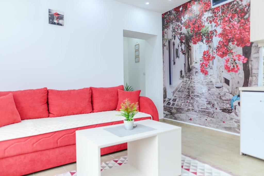 a living room with a red couch and a white table at Sara 4 in Soko Banja