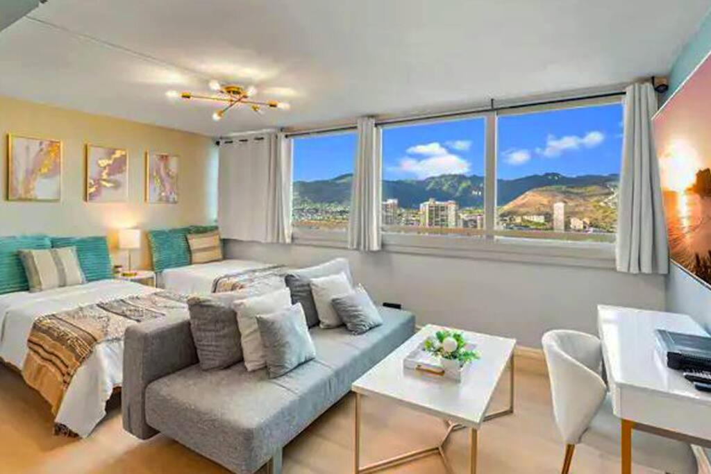 1 dormitorio con cama, sofá y ventanas en Waikiki Beach 1BR Luxury Condo!, en Honolulu