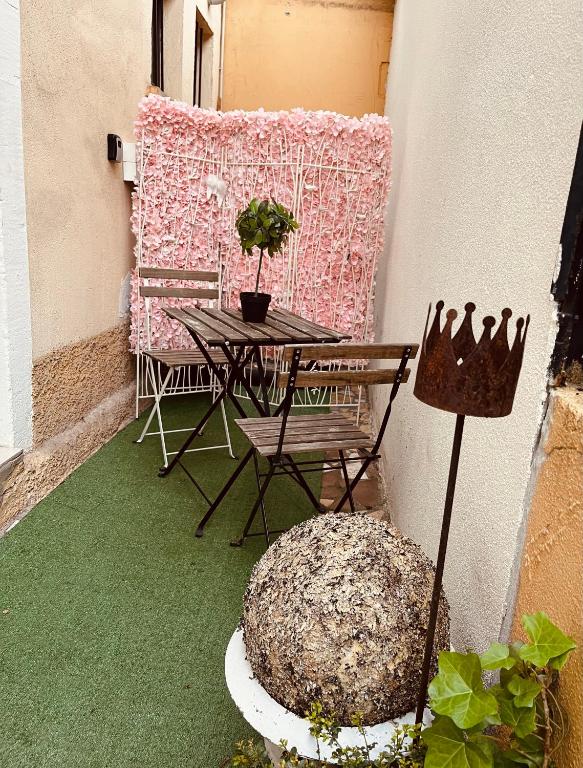 une terrasse avec une table, des chaises et une plante dans l'établissement Comme une suite d hôtel, 45M2 Chez Regine, à Schiltigheim