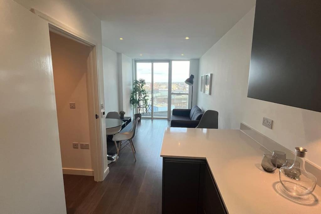 uma cozinha e sala de estar com mesa e cadeiras em Cozy Living with Balcony View em Croydon