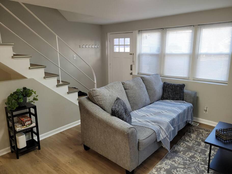 ein Wohnzimmer mit einem Sofa und einer Treppe in der Unterkunft Davenport Dwellings-Two Bedroom Close to UNMC in Omaha