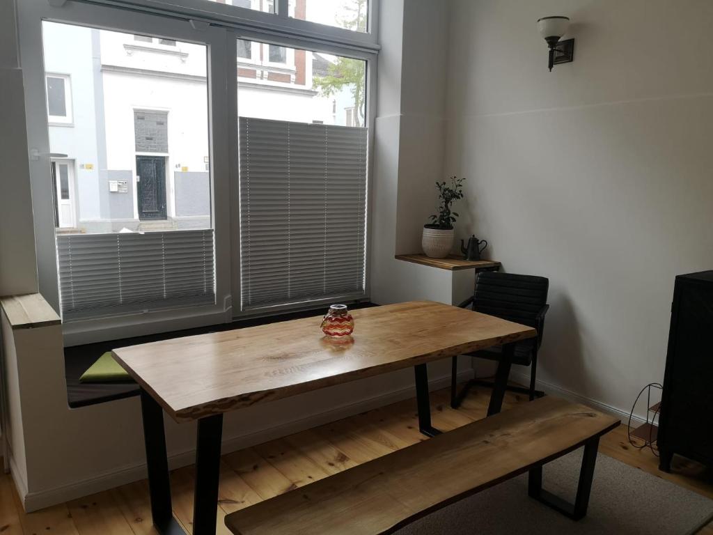 einen Holztisch in einem Zimmer mit Fenster in der Unterkunft Exklusive 3-Zimmer-Wohnung, 2 Ebenen, Messe, Zentrum, 67 m2 in Bremen
