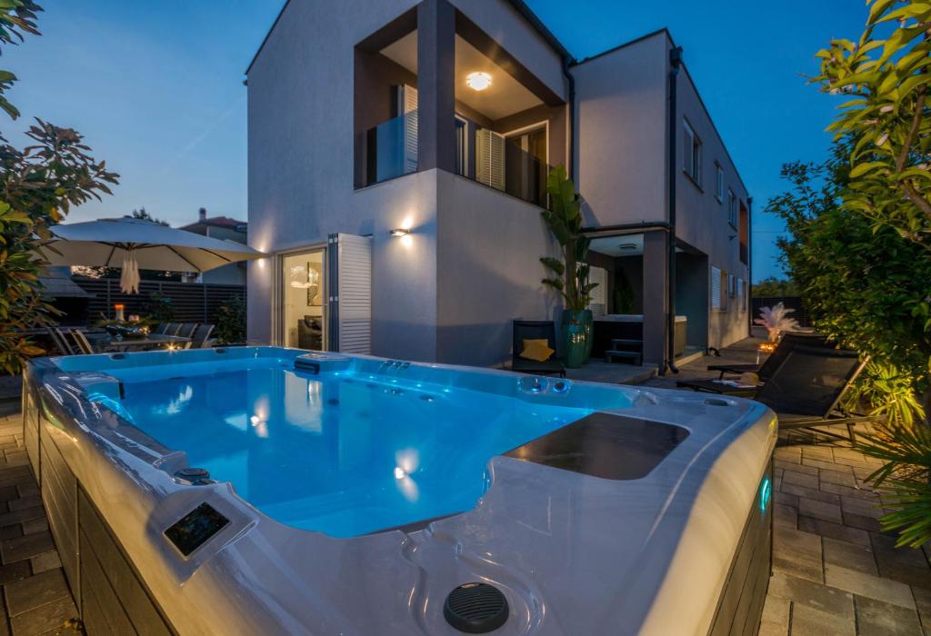 a bath tub in front of a house at Ledenko Holiday Home Private Pool & Jacuzzi in Biograd na Moru