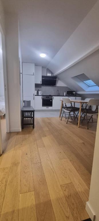 Habitación vacía con suelo de madera y cocina en Appartement pré de Paris, en Gagny