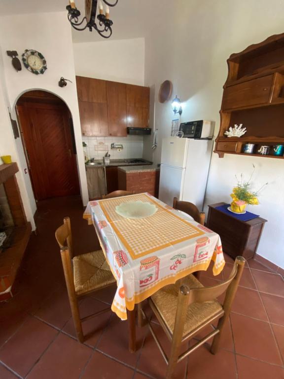 a kitchen with a table and chairs and a refrigerator at Casetta Marina Residence in Santa Luria