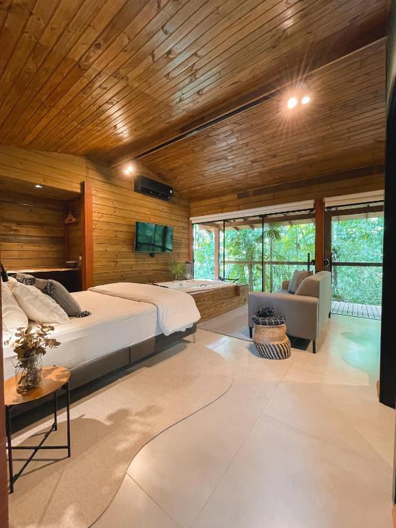 1 dormitorio con 1 cama grande y sala de estar en Cabana equipada em meio à natureza em Pomerode en Pomerode