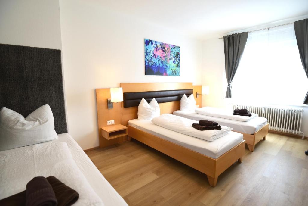 um quarto de hotel com duas camas e uma janela em PM-APART Premstätten em Premstätten