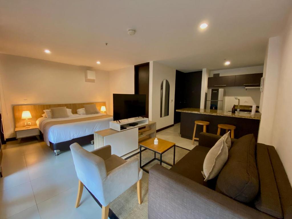 Habitación de hotel con cama y sala de estar. en Suite Estelar - A Pasos del Aeropuerto en Rionegro