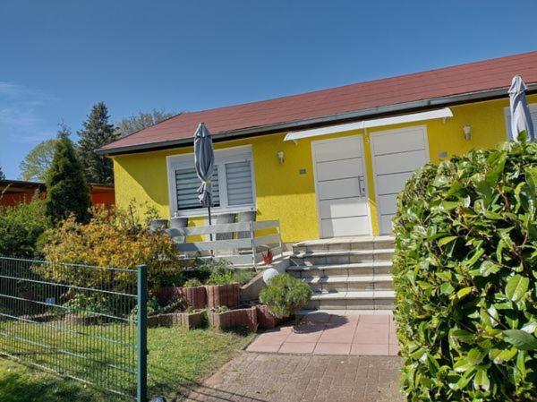 uma casa amarela com um telhado vermelho em Ferienhaus Oscar em Ahlbeck