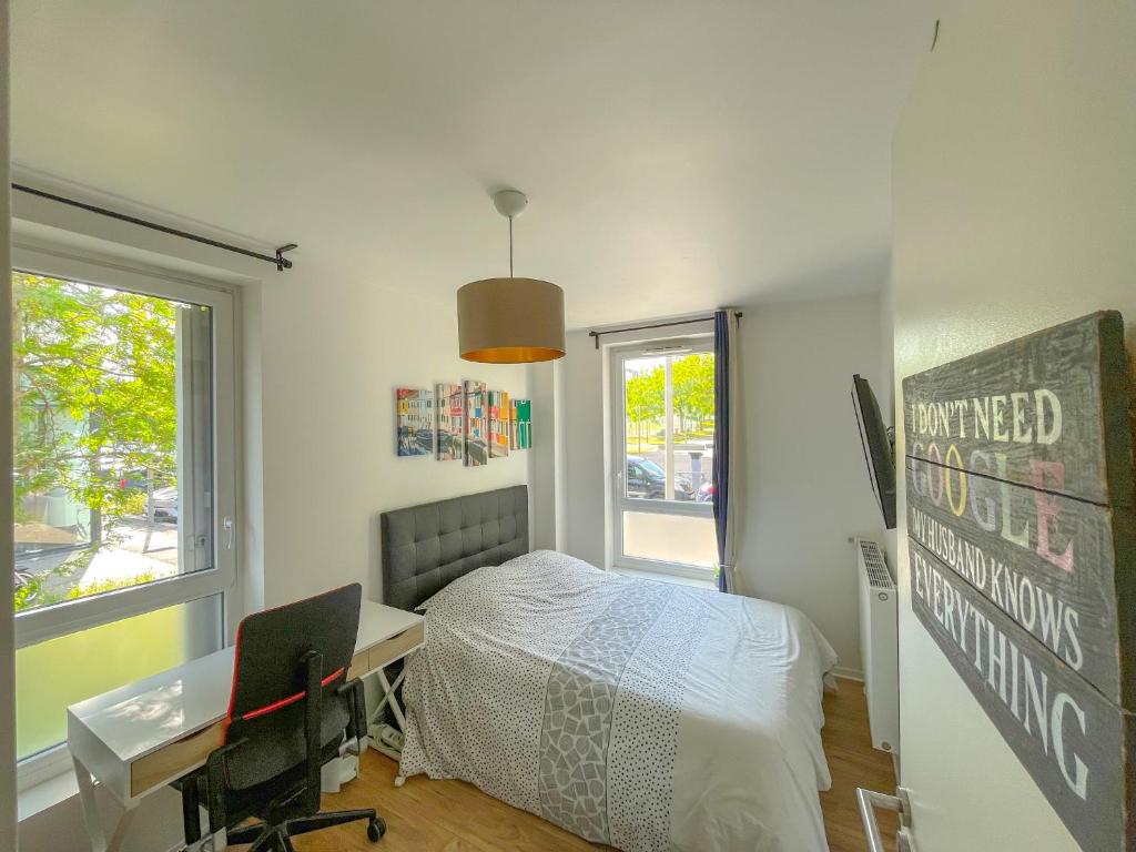 Schlafzimmer mit einem Bett, einem Schreibtisch und einem Fenster in der Unterkunft Chambre à Nanterre Université proche La Defense Aréna et Paris in Nanterre