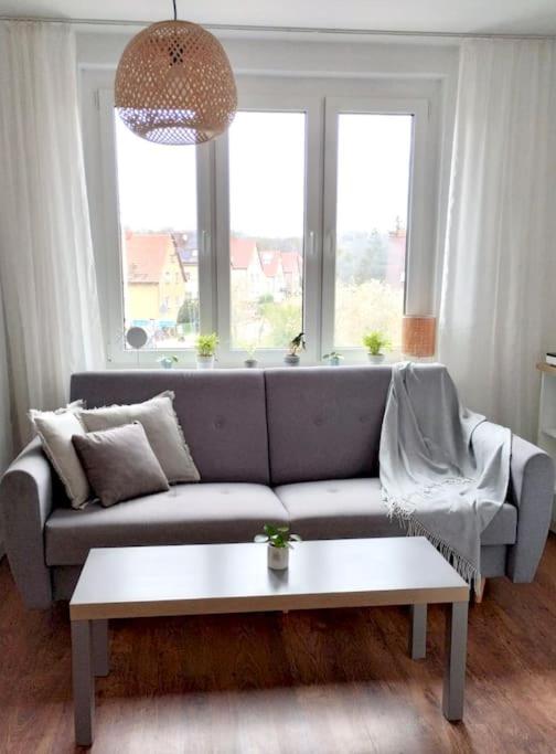 salon z kanapą i stołem w obiekcie Apartament Plaża Zachodnia - 400 m do morza w Kołobrzegu