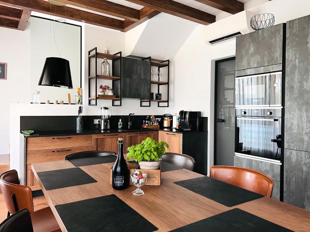 a kitchen with a dining room table with a bottle of wine at Casa di Alex | Sirmione in Sirmione