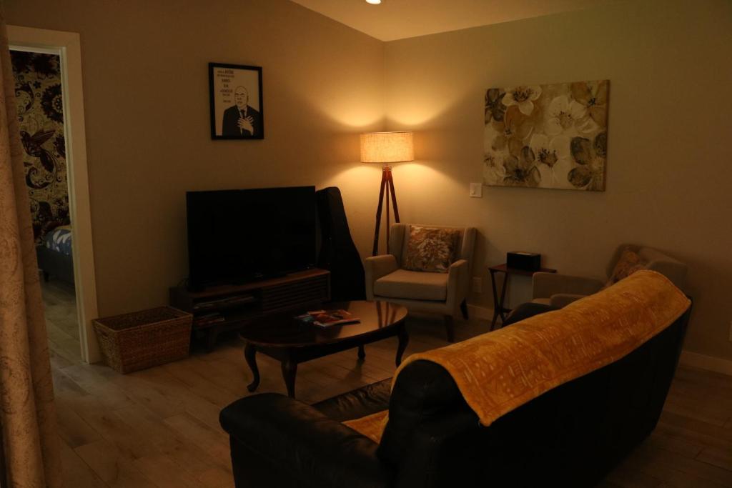 uma sala de estar com um sofá e uma televisão em Charming Garden Apartment em University Place