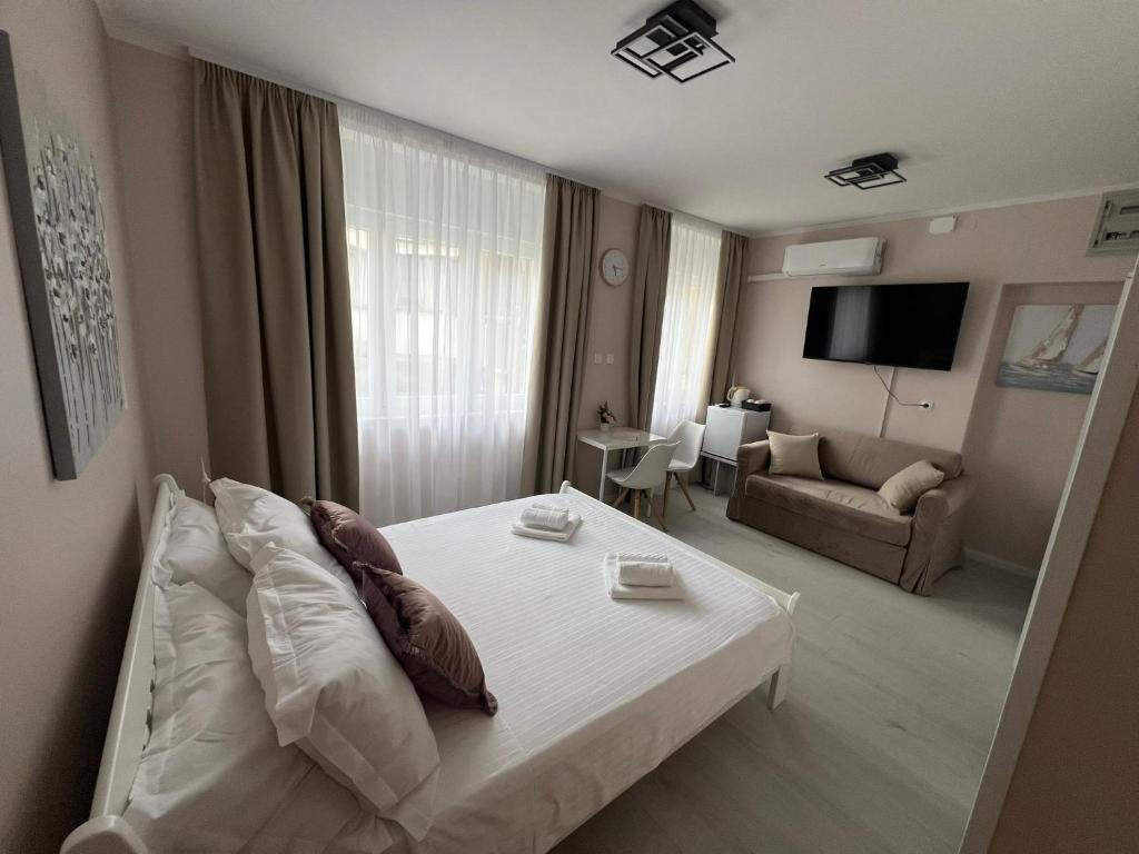a bedroom with a white bed and a living room at A-more accommodation in Split