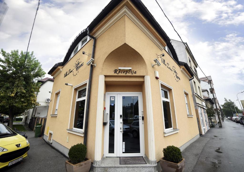 un bâtiment jaune avec une porte dans une rue dans l'établissement Villa Zrina, à Zagreb