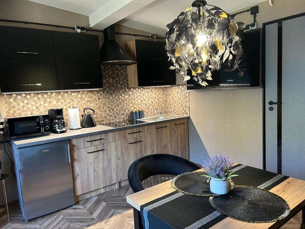 Una cocina con una mesa y una lámpara de araña. en Apartament przy plaży Marlina, en Niewiesze