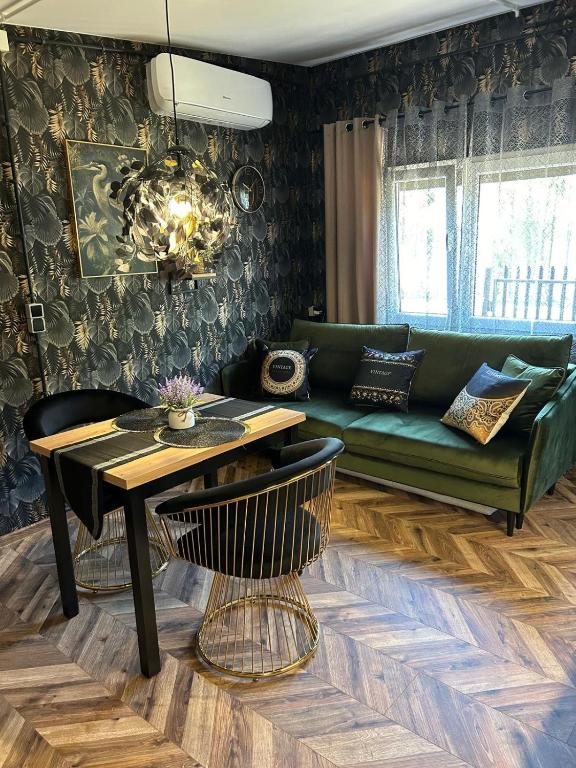 a living room with a green couch and a table at Apartament przy plaży Marlina in Niewiesze