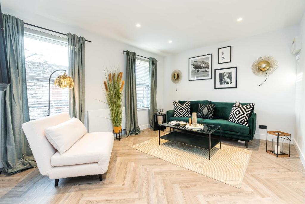 a living room with a green couch and a white chair at WestKensington-BaronsCourt-StylishDuplex-2bedrooms2Bath-Luxury in London