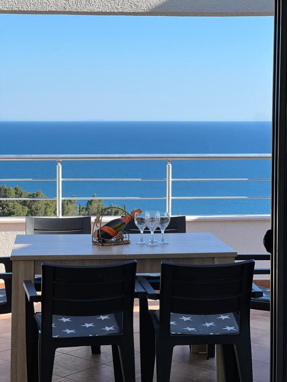 a table and chairs with wine glasses on a balcony at Regatta Inn in Ulcinj