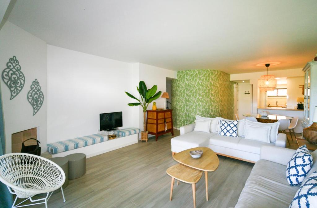 a living room with a white couch and a table at FLH Victory Village Apartamento Quinta do Lago in Almancil