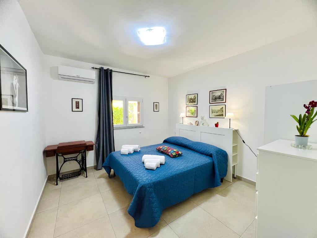 a bedroom with a blue bed with towels on it at L'Angolo del Saraceno in Carini