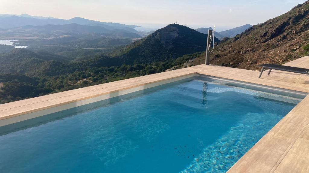 een zwembad met uitzicht op de bergen bij Villa Padula in Olmeta-di-Tuda