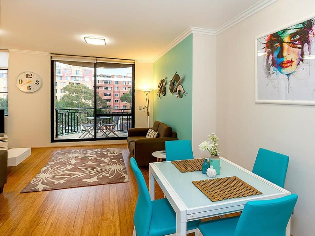 - un salon avec une table et des chaises bleues dans l'établissement Thriving city location dining hub near CBD, à Sydney