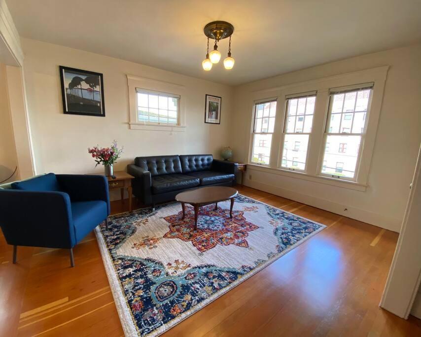 uma sala de estar com um sofá e um tapete em Historic Downtown Riverview Flat, No 3 em Astoria