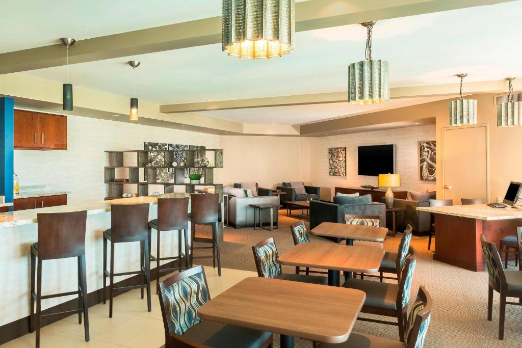 un restaurante con mesas y sillas y un bar en Sheraton Mesa Hotel at Wrigleyville West en Mesa