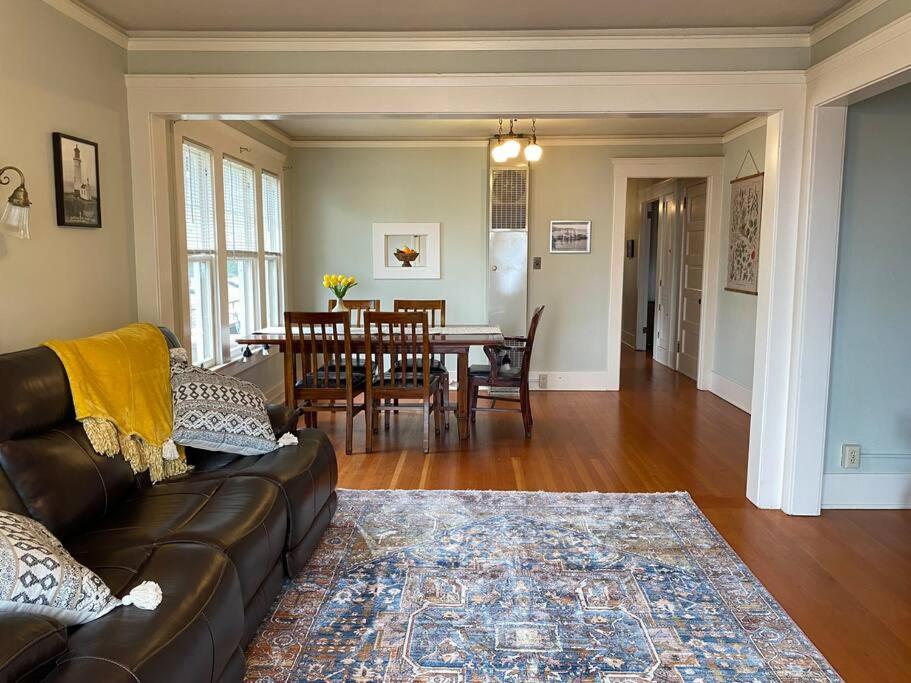 uma sala de estar com um sofá e uma sala de jantar em Historic Downtown Riverview Flat, No. 4 em Astoria