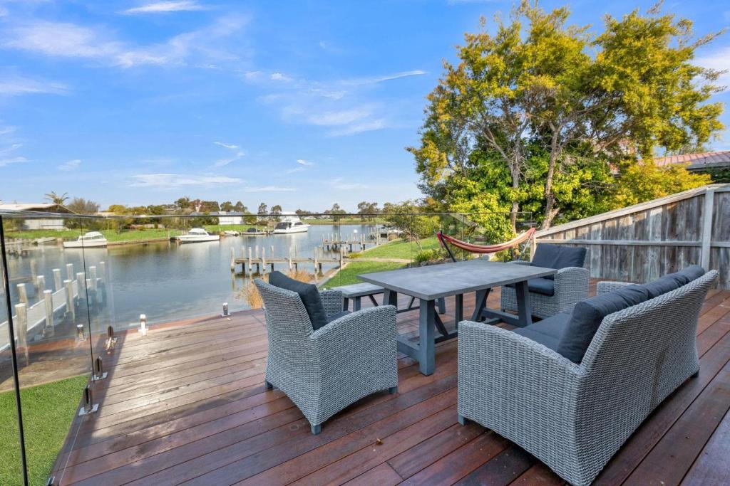 a deck with a table and chairs and a view of a river at Clipper Cove in Paynesville