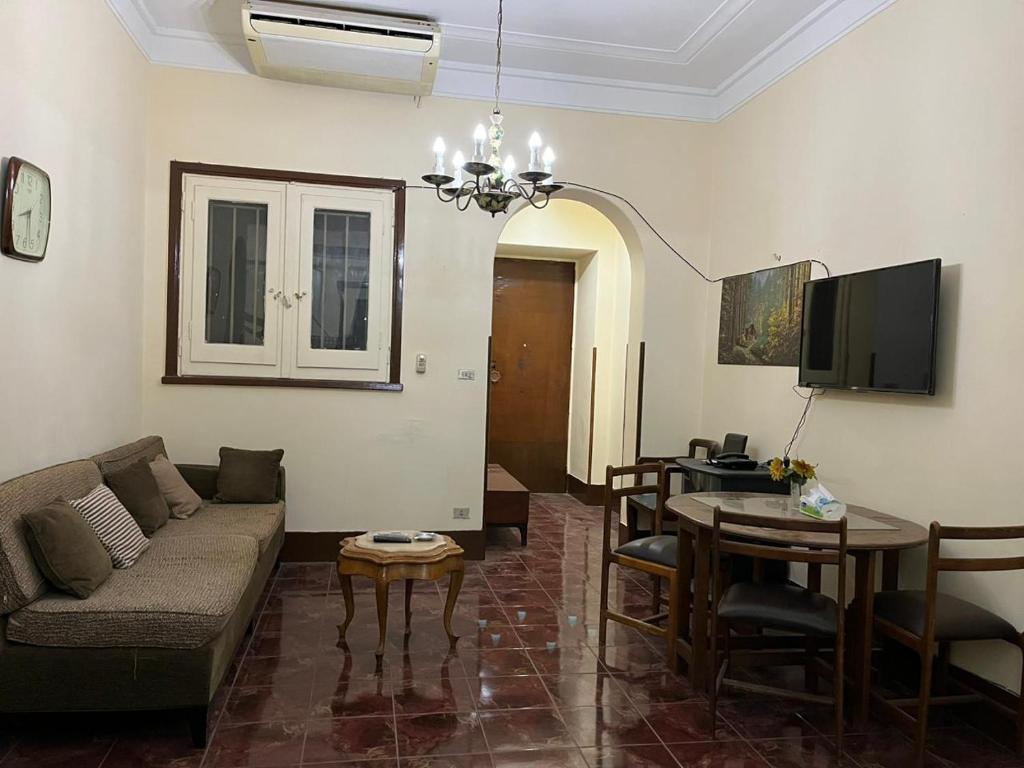 Beautiful apartment in the heart of cairo في القاهرة: غرفة معيشة مع أريكة وطاولة