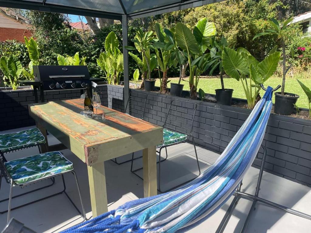 einen Picknicktisch und eine Hängematte unter einem Sonnenschirm in der Unterkunft Modern studio with private patio in Dernancourt