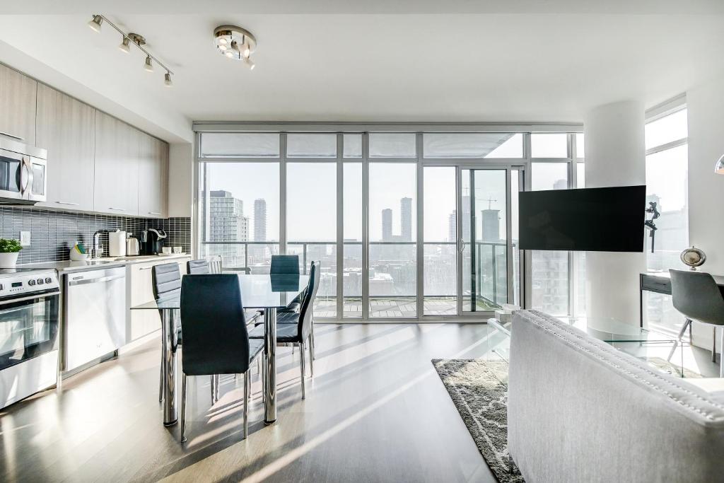 多倫多的住宿－Epic 2BR Condo w/ Panoramic CN Tower/City View，厨房以及带桌椅的用餐室。