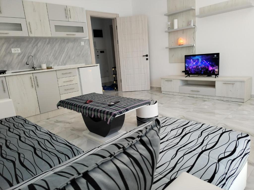 a white kitchen with a table and a tv in it at BellaVita goldap in Prokuplje