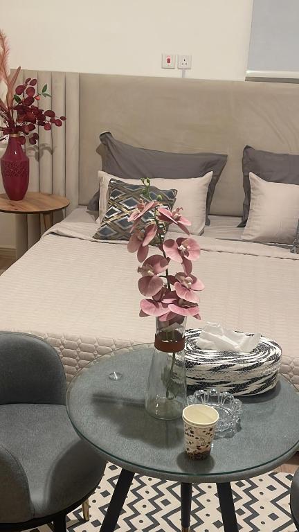 a room with a bed and a table with flowers on it at ستارت 3 in Hail