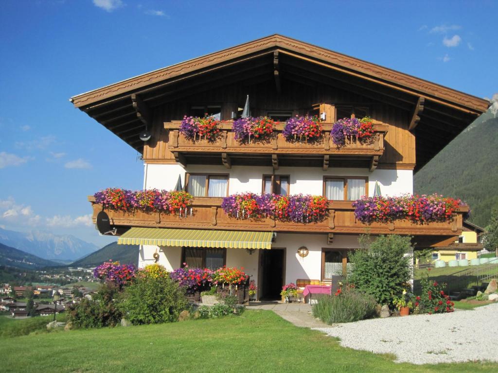 ein Gebäude mit Blumen auf den Balkonen in der Unterkunft Haus Fernblick in Neustift im Stubaital