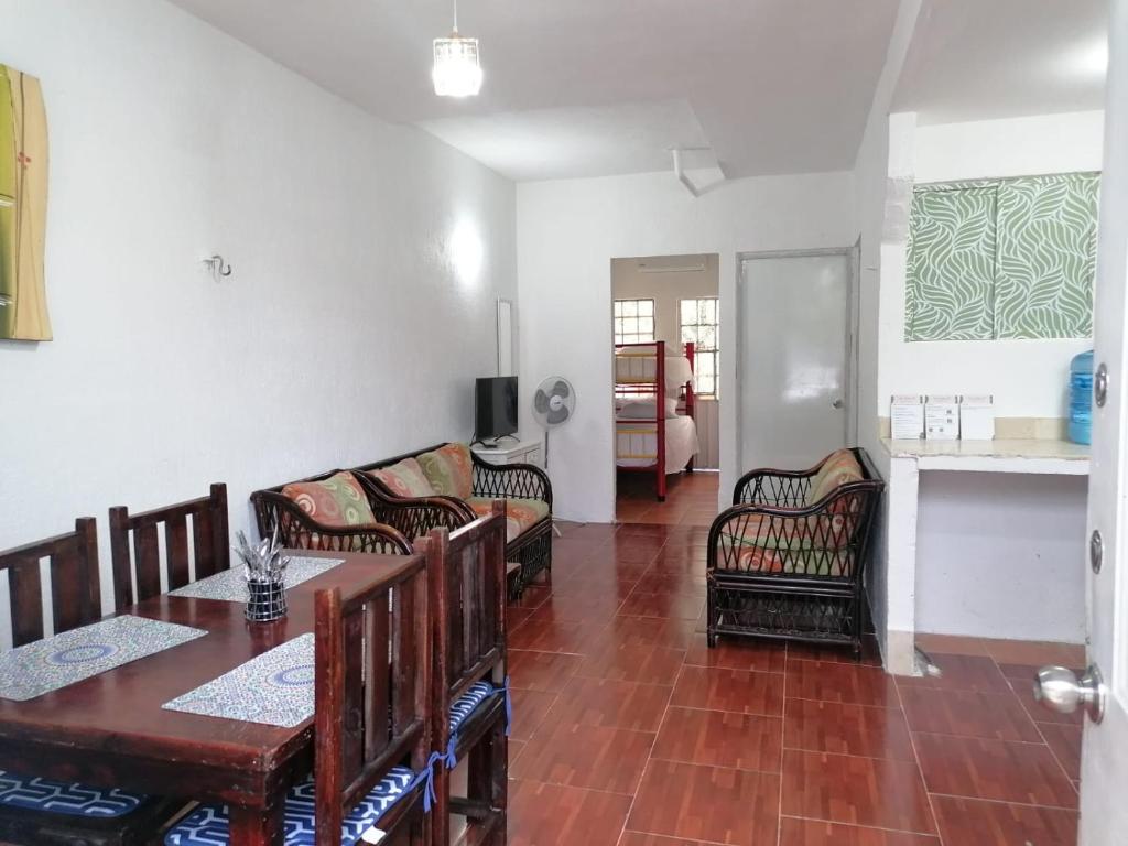 sala de estar con mesa, sillas y sofá en La casa 19 en Cancún