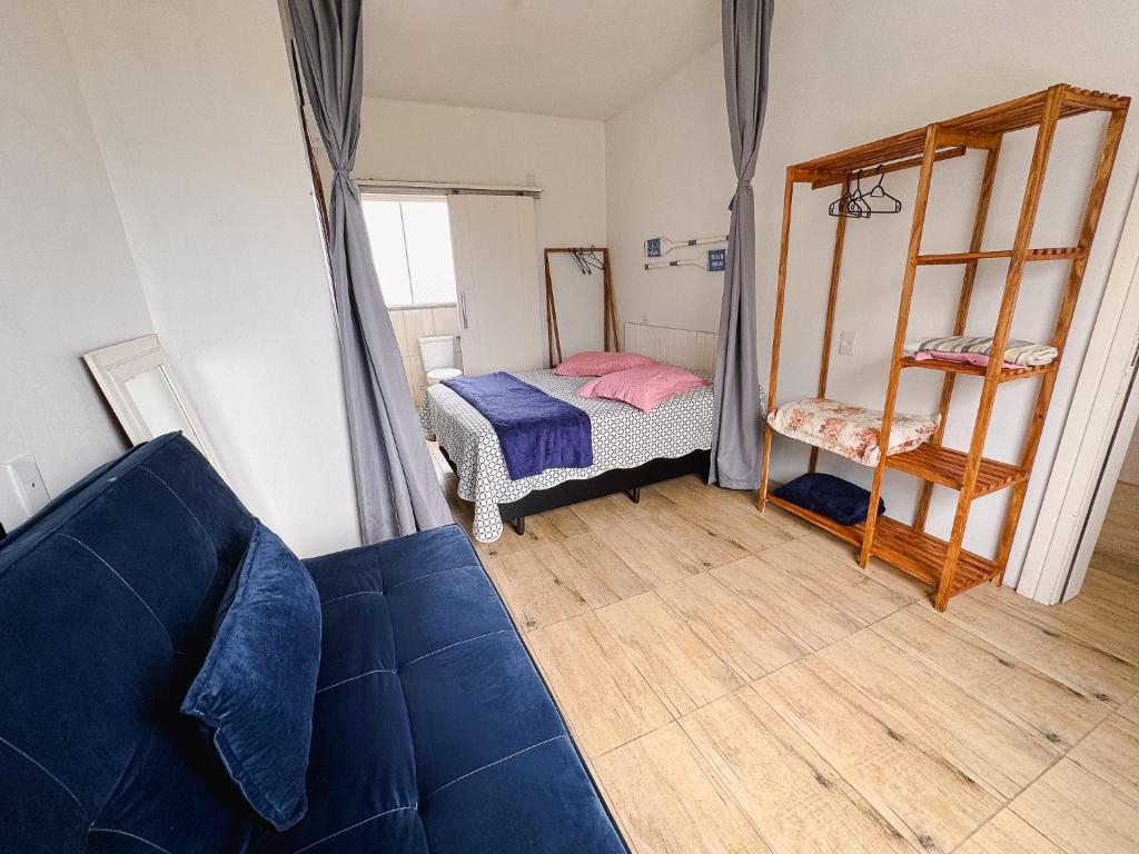 uma sala de estar com um sofá azul e um quarto em Bella Praia Apartamento Remo em Passo de Torres