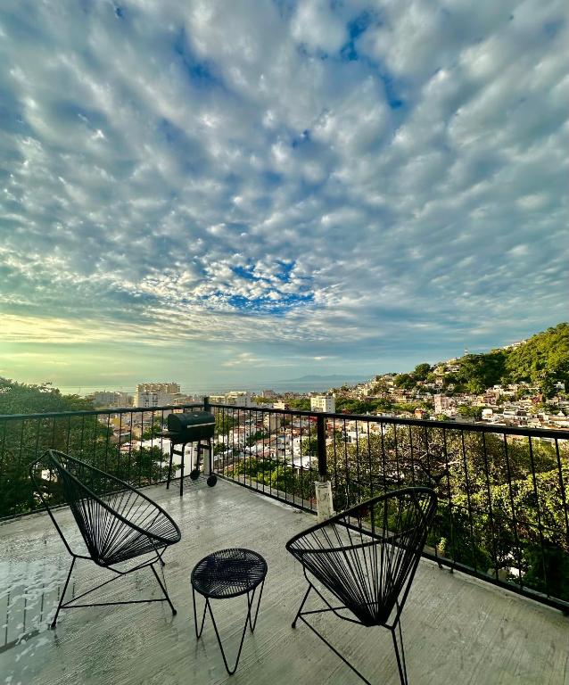 two chairs and a piano on a balcony with a view at para rentar no se puede in Puerto Vallarta