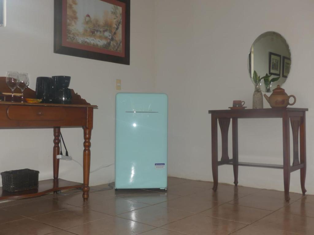 a blue refrigerator next to a table and a mirror at Hotel Cacao Río Celeste in Bijagua