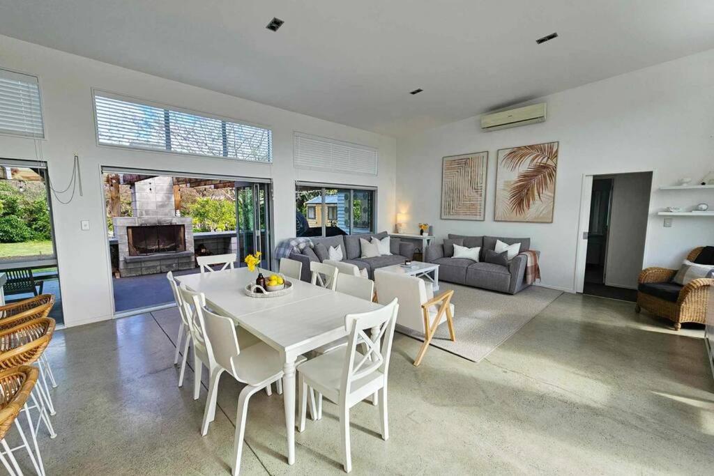 a living room with a white table and chairs at The Mangawhai Bach in Mangawhai